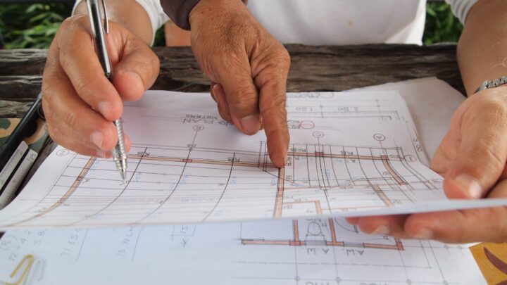 Bouwbegeleider en bouwprofessionals overleggen over een bouwproject